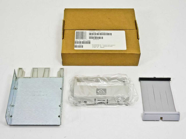 Microtech BKT-600 drive installation kit contents laid out next to original brown cardboard box — metal bracket, plastic sled in bag, and IDE ribbon cable visible