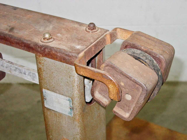 Fairbanks 41-3132 beam mechanism close-up – counterweight bracket, sliding poise, and pivot hardware with surface rust