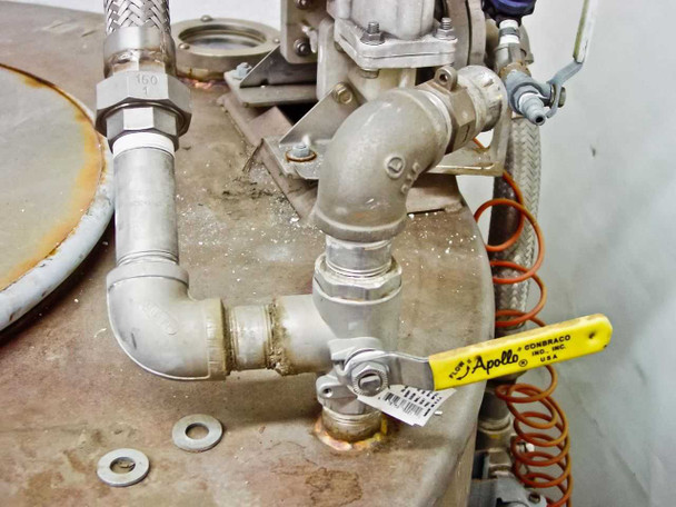 Close-up of top plumbing assembly with Apollo Conbraco ball valve (yellow handle), elbow fittings, and diaphragm pump base