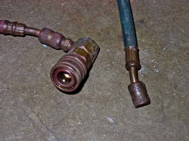 Sun Electric MRC 400 – R-12 quick-disconnect service hose fittings on floor, showing brass couplers