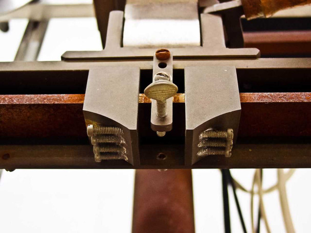 Adjustable clamp and guide rail assembly showing thumbscrew clamp block on horizontal support rod