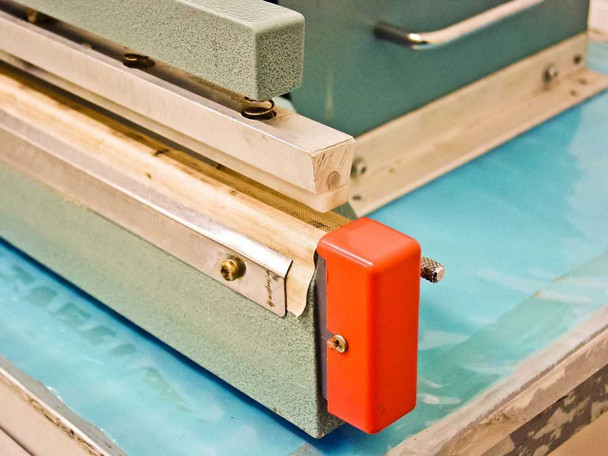 AIE AIE-605A1 close-up of right end of sealing bar with red end cap and tension adjustment hardware
