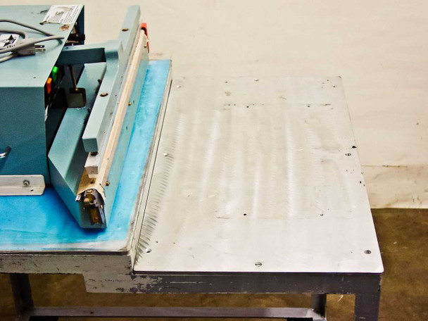 AIE AIE-605A1 top view showing sealing bar assembly and aluminum work table surface with scuff marks
