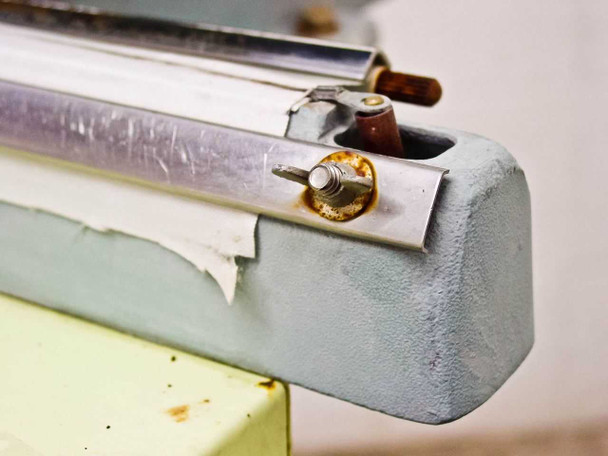 TEW TISF-452 opposite sealing jaw end showing surface scratches on bar and rust on fastener hardware