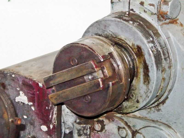 Close-up of lathe spindle nose showing drive key/slot mechanism with visible corrosion and wear