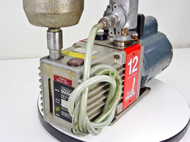 Edwards E2M12 vacuum pump – rear three-quarter view showing oil sight glass, oil fill port labeled 'Fomblin 16/6 Oil Only', and braided foreline hose