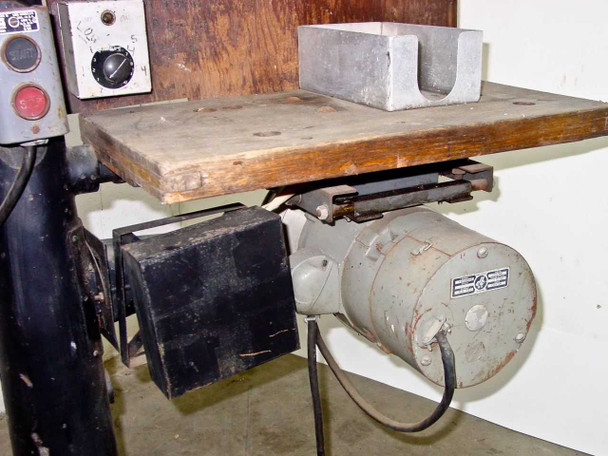 Underside of work table showing motor and drive mechanism with metal belt/pulley assembly