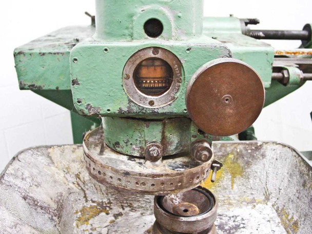 Close-up of Barnes-Desenberg Model 5 upper head with dial indicator gauge and bronze lap disc on work table