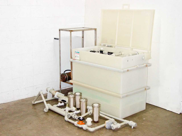 HDPE chemical reservoir tank with lid open showing interior piping connections and control panel — full system three-quarter view with filter manifold