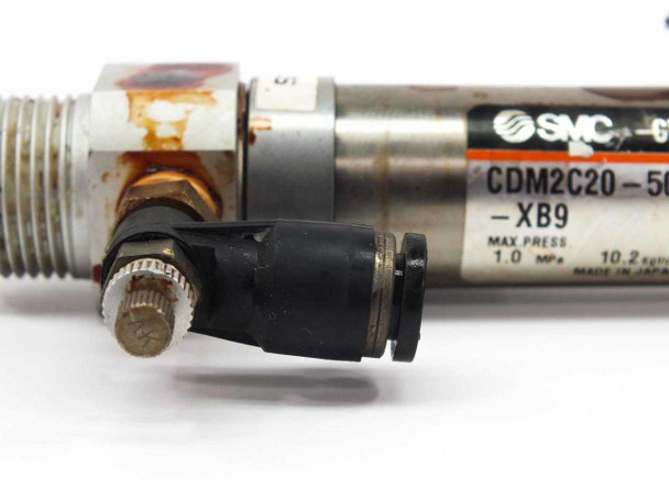 SMC CDM2C20-50-H7BL cylinder body closeup showing push-in pneumatic port fittings and XB9 label
