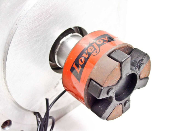 Close-up of Lovejoy flexible jaw coupling on Emoteq QS05600 servo motor output shaft showing rubber spider insert and cast iron hubs