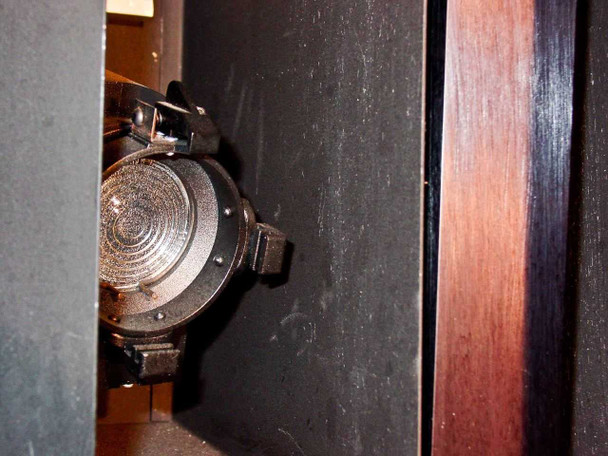 Close-up of incandescent side wall bulb socket inside CRP L-207-B chamber interior — dusty socket with clip-style lamp holder