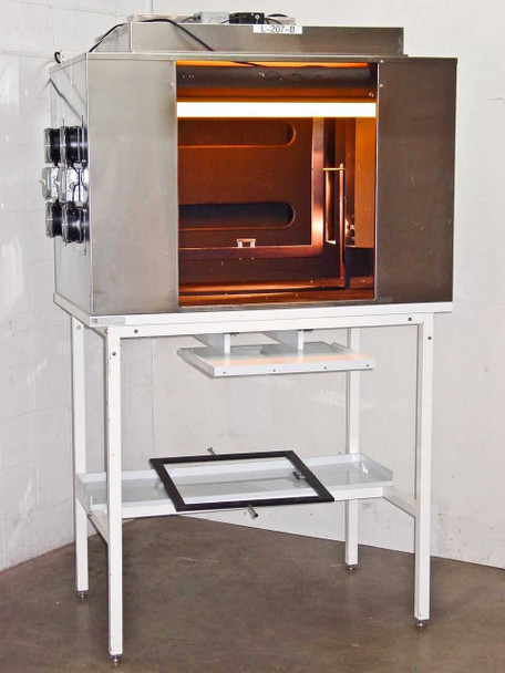 CRP L-207-B light box exposure chamber powered on with amber interior lighting, mounted on white metal table stand — front 3/4 view