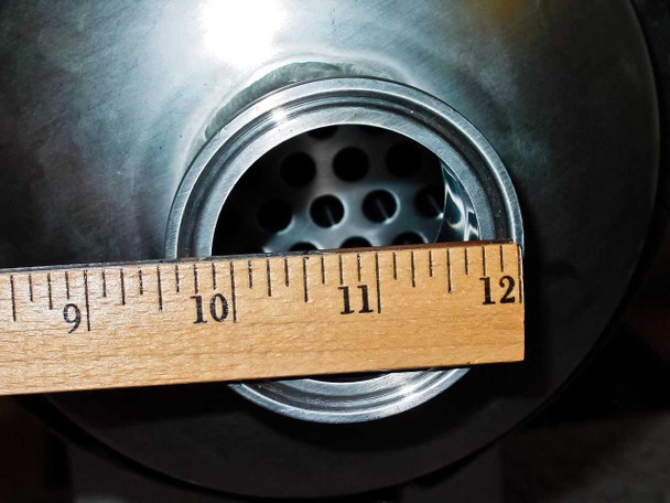 Ruler measurement across large end opening — tube sheet approximately 6.5 inches in diameter with multiple tube holes visible