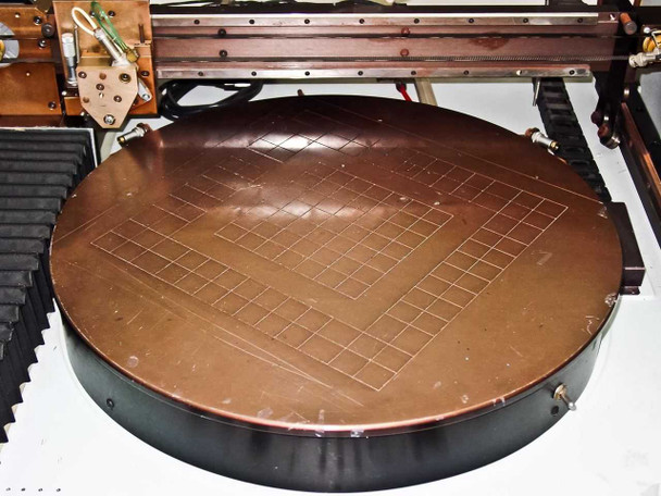 Close-up of Villa Precision GS-210 large circular vacuum chuck stage showing completed scribe grid pattern on glass substrate