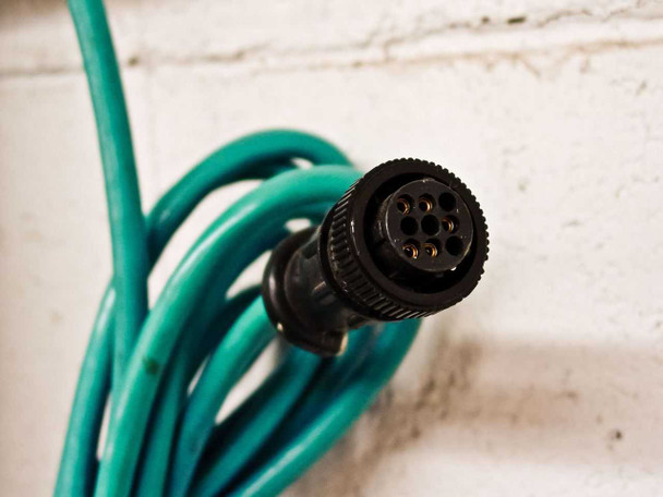 Close-up of multi-pin circular connector on teal cable attached to MTS Level Plus A910750172 transmitter