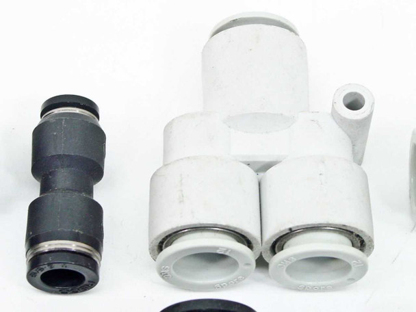Mixed SMC push-to-connect fittings — black straight union alongside white Y-splitter and Y-style fittings