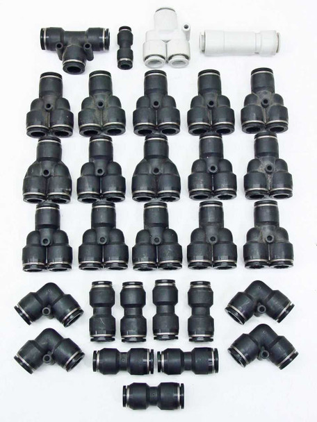 SMC push-to-connect pneumatic fittings lot — full spread showing T, Y, elbow, straight union, and splitter connectors in black and white