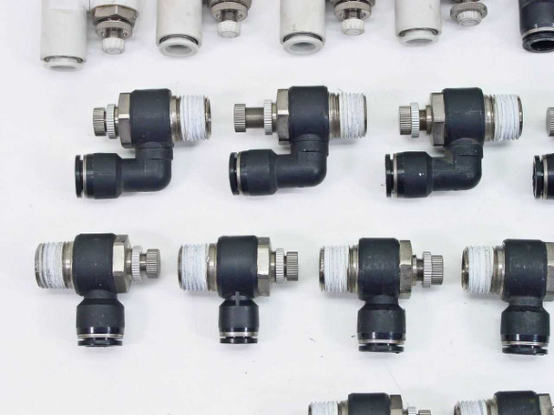 SMC black speed controller elbow fittings and white straight connectors — close-up showing knurled flow control adjustment and push-in ports