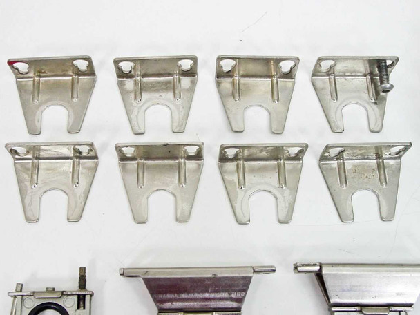 Eight stainless steel U-channel cylinder mounting brackets laid flat in two rows of four, with three larger O-ring cylinder mount bracket assemblies partially visible at bottom