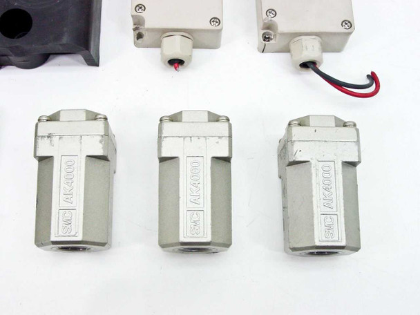 Three SMC AK4000 inline check valves front view showing SMC brand markings, two ZTHI BOXTC-9A enclosures with lead wires behind
