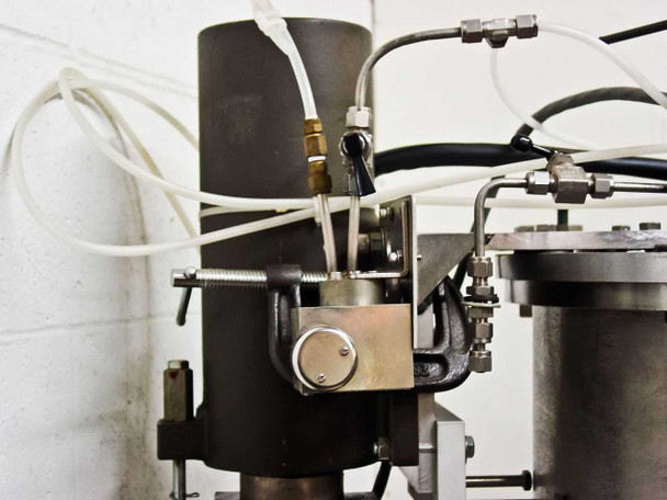 Ion Tech ion source assembly close-up showing gas lines, fittings, mounting bracket, and feed-through connections at top of bell jar