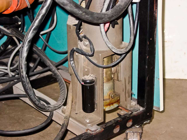 Lower frame corner detail showing corrosion/rust on cart frame member, with bundled cables and component visible