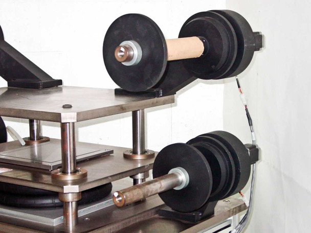 Side view of film roll arbors showing IMS stepper motor-driven rubber idler wheels and support arm assembly