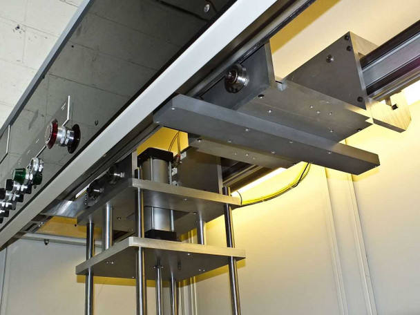 Overhead view of BF-200 upper transport/bridge assembly showing linear actuators, rollers, and illuminated work area beneath