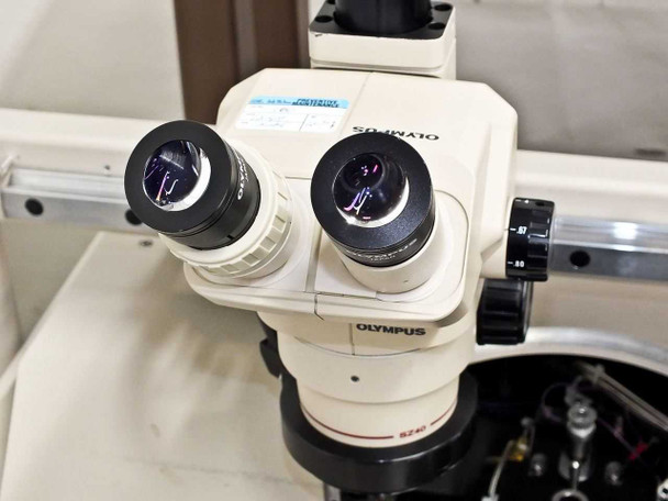 Close-up of Olympus SZ40 binocular stereo microscope head showing eyepieces and zoom knob on wafer prober