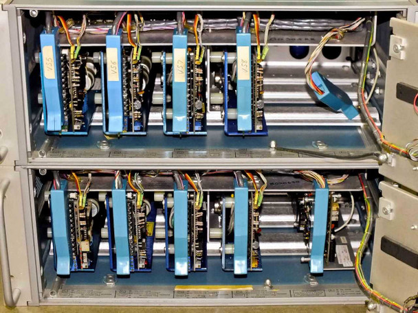 Interior of Tektronix 1140A Programmable Power Supply units with covers open — showing two rows of blue plug-in modules and internal wiring harnesses