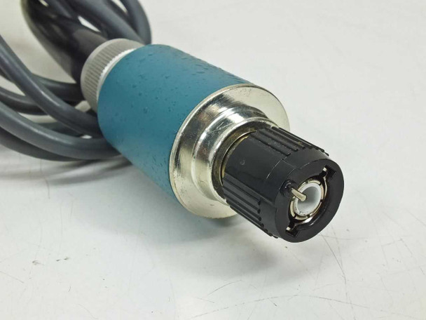 Close-up of Tektronix P6009 probe handle showing teal grip body, compensation adjustment knob, and scope connector end