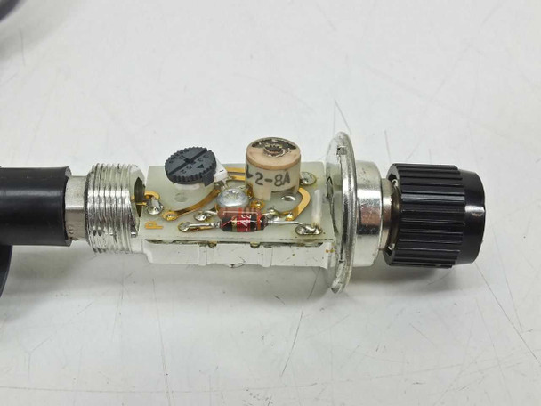 Tektronix P6009 probe with housing section removed revealing internal compensation circuit board, trimmer capacitor, and components