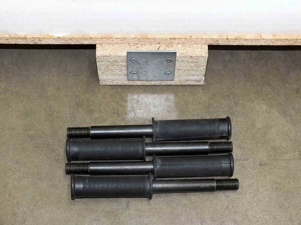 Underside of BioRobot 8000 custom shipping crate showing metal anchor plate and five large threaded hold-down bolts