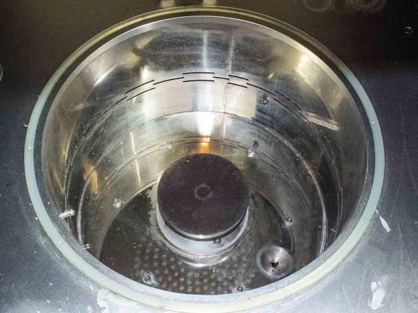 Interior view of stainless steel cylindrical ultrasonic cleaning tank showing transducer plate at bottom and perforated sidewalls