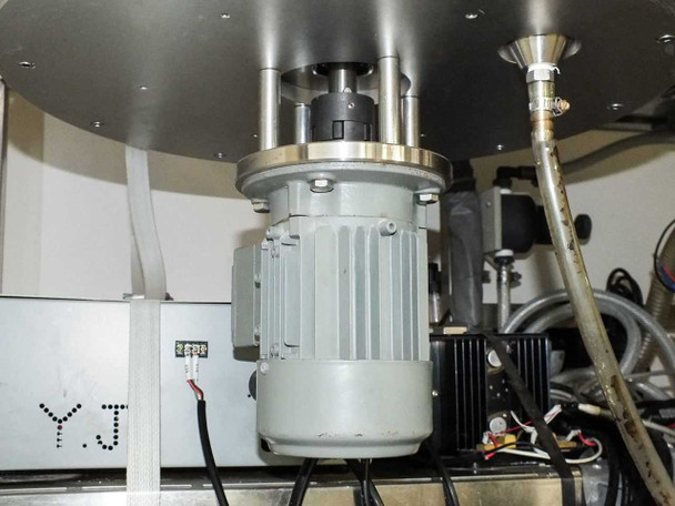 Close-up of disc/wafer turntable drive motor mounted beneath rotating platen inside cleaning enclosure