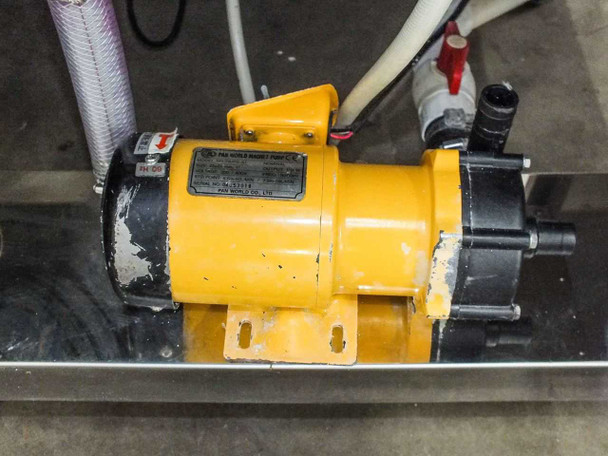Close-up of yellow Pan World magnet circulation pump (model NH-200PS-3J) mounted under bench with hose connections
