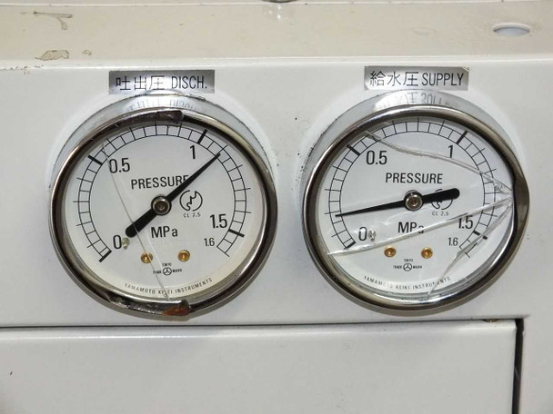 Close-up of dual Yamamoto Keiki pressure gauges labeled DISCH. and SUPPLY, both graduated to 1.6 MPa — right gauge shows cracked glass