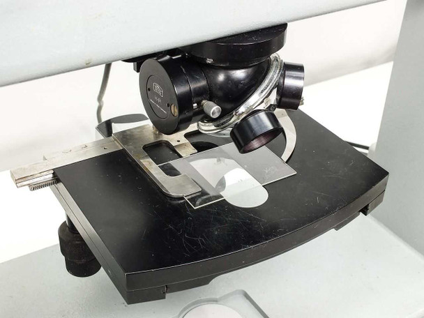 Large flat wafer stage and focus block area — metal wafer holder and guide on stage, coarse focus knob visible at right of microscope body