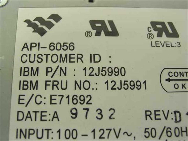 IBM API-6056 power supply label closeup showing IBM P/N 12J5990, FRU 12J5991, E/C E71692, Date 9732, Rev D, and 100-127V 50/60Hz input specification