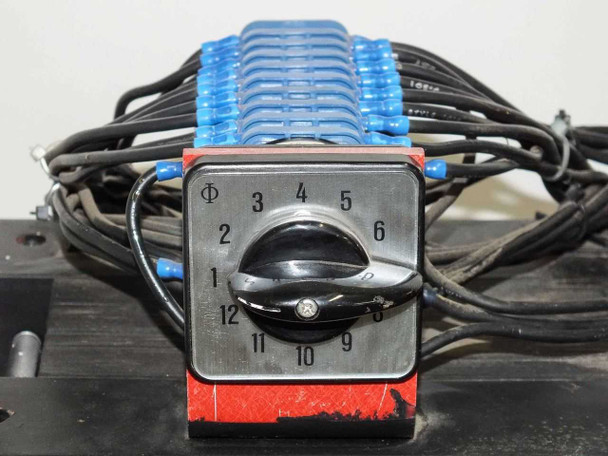 Kraus & Naimer rotary tap selector knob — 12-position rotary switch labeled 1 through 12 with phi symbol, mounted on red bracket above blue terminal block assembly