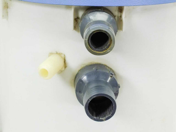 Close-up of Plastican housing filter side-mount barbed fittings showing two large black barbed ports and one small cream plastic fitting with sealant residue