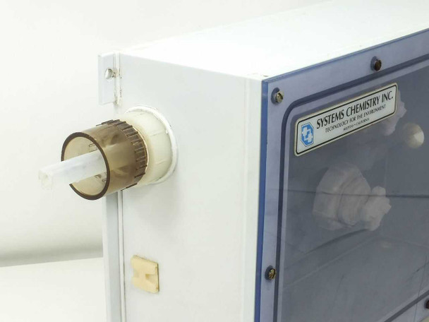 Fluoroware 201-35 sealed enclosure — left side detail showing external port fitting and Systems Chemistry Inc. label on enclosure corner