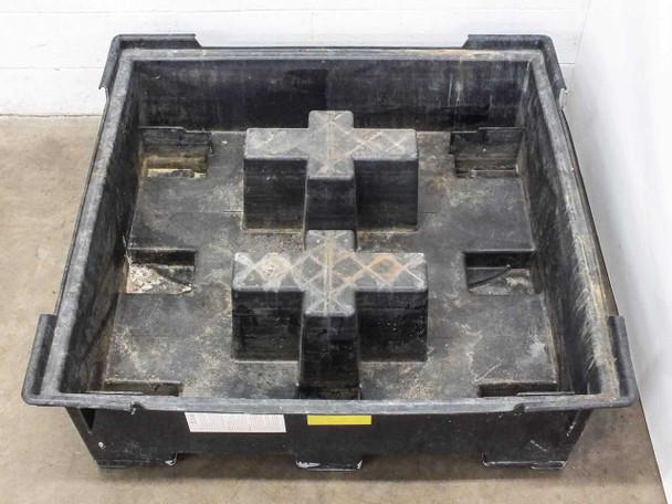 Interior of HDPE sump pallet with grating removed, showing four forklift-entry support pedestals and sump floor with minor residue deposits