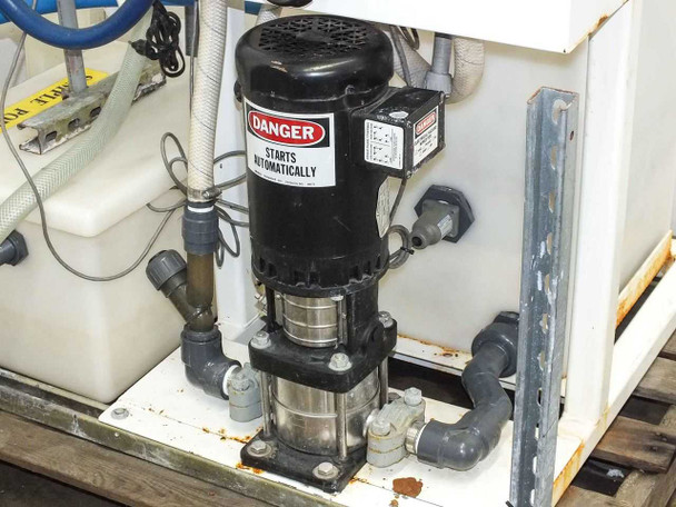 Baldor industrial motor close-up mounted to pump assembly on tank, with Danger Starts Automatically warning label