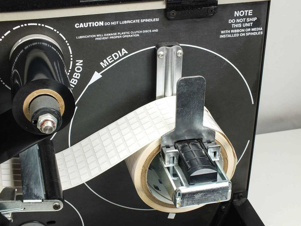 Brady 300X-Plus media spindle area close-up showing label roll loaded and ribbon/media path routing diagram