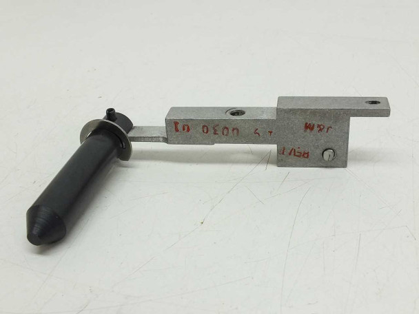 Actuator arm close-up showing machined aluminum slide, mounting holes, rubber-tipped plunger, and red ink markings