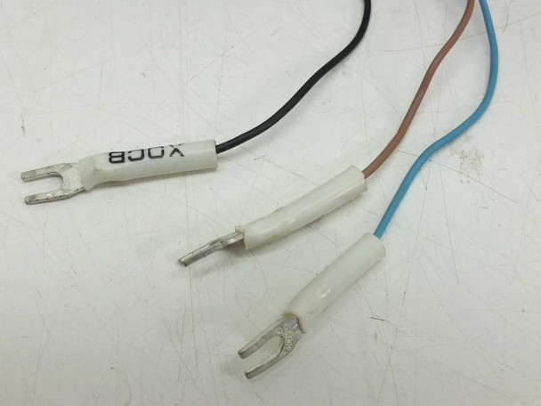 Omron E3X-A11 pigtail wire ends showing three fork spade terminals — black (output), brown (10-30VDC), blue (0V)