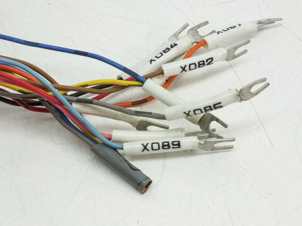 Close-up of multi-conductor cable free ends showing color-coded wires with white labeled spade fork terminals marked X089, X080, X082, X084, X08Y