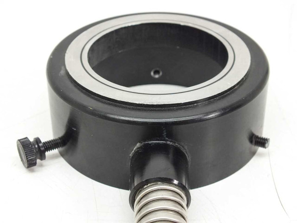 Ring housing rear/top view showing black anodized body, inner bore, two thumbscrews installed on sides, and flex cable attachment point